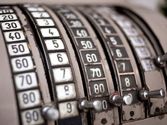 The numbered dial of an old weighing scale.